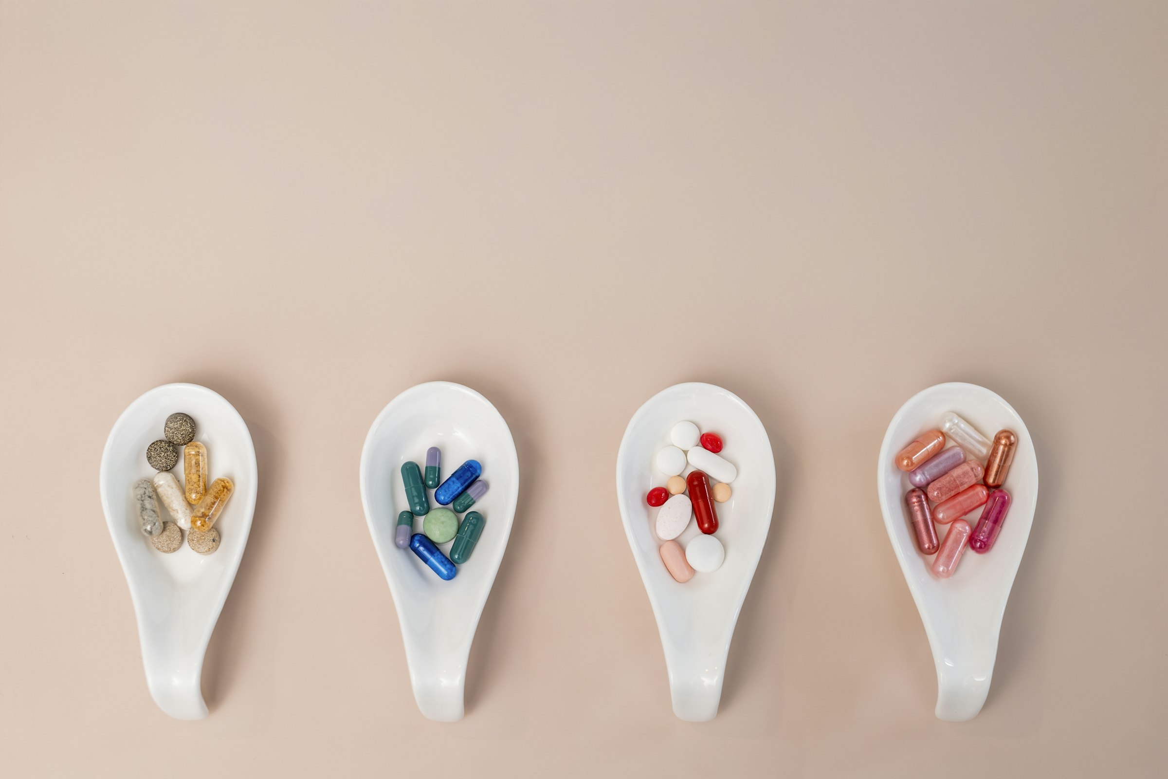 Colorful supplement pills arranged on spoons